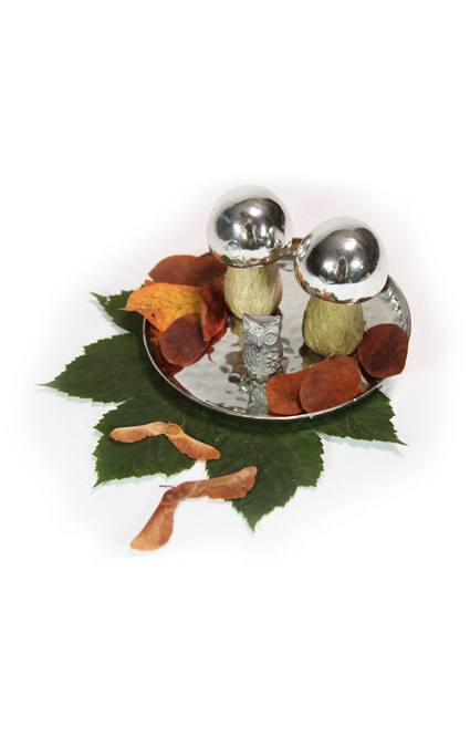 Ein Silbertablett mit künstlichen Pilzen als Herbstdekoration