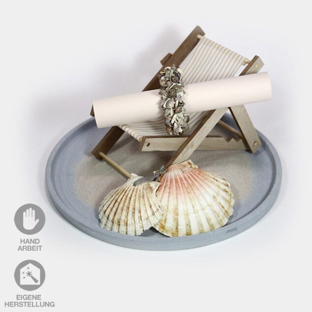 Tablett mit Miniatur-Liegestuhl dekoriert mit Muscheln, Sand und einem Muschel-Ring für einen Gutschein-oder Geldgeschenk für eine Reise.