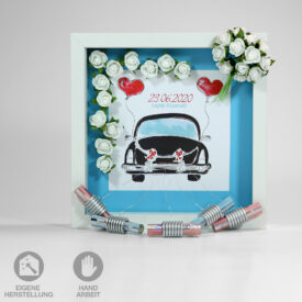 Geschenk-Rahmen zur Hochzeit "Romantik Hellblau" in schwarz, weiß, rot und hellblau gehalten. Geschmückt mit einem Brautstrauß und einer Ranke aus weißen Rosen, einem schwarzen, klassischen Oldtimer, Herz-Luftballons und Blechdosen. Individuell eingedruckt werden Hochzeits-Datum und der Vorname der beiden frisch Vermählten.
