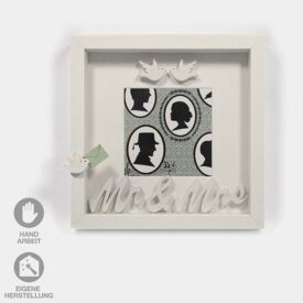 Ein Geschenk-Rahmen für eine Hochzeit. Der weiße Rahmen hat einen Silouetten-Nostalgie-Hintergrund und ist mit weißen Tauben verziert. Dazu ein Schriftzug "Mrs.&Mr."