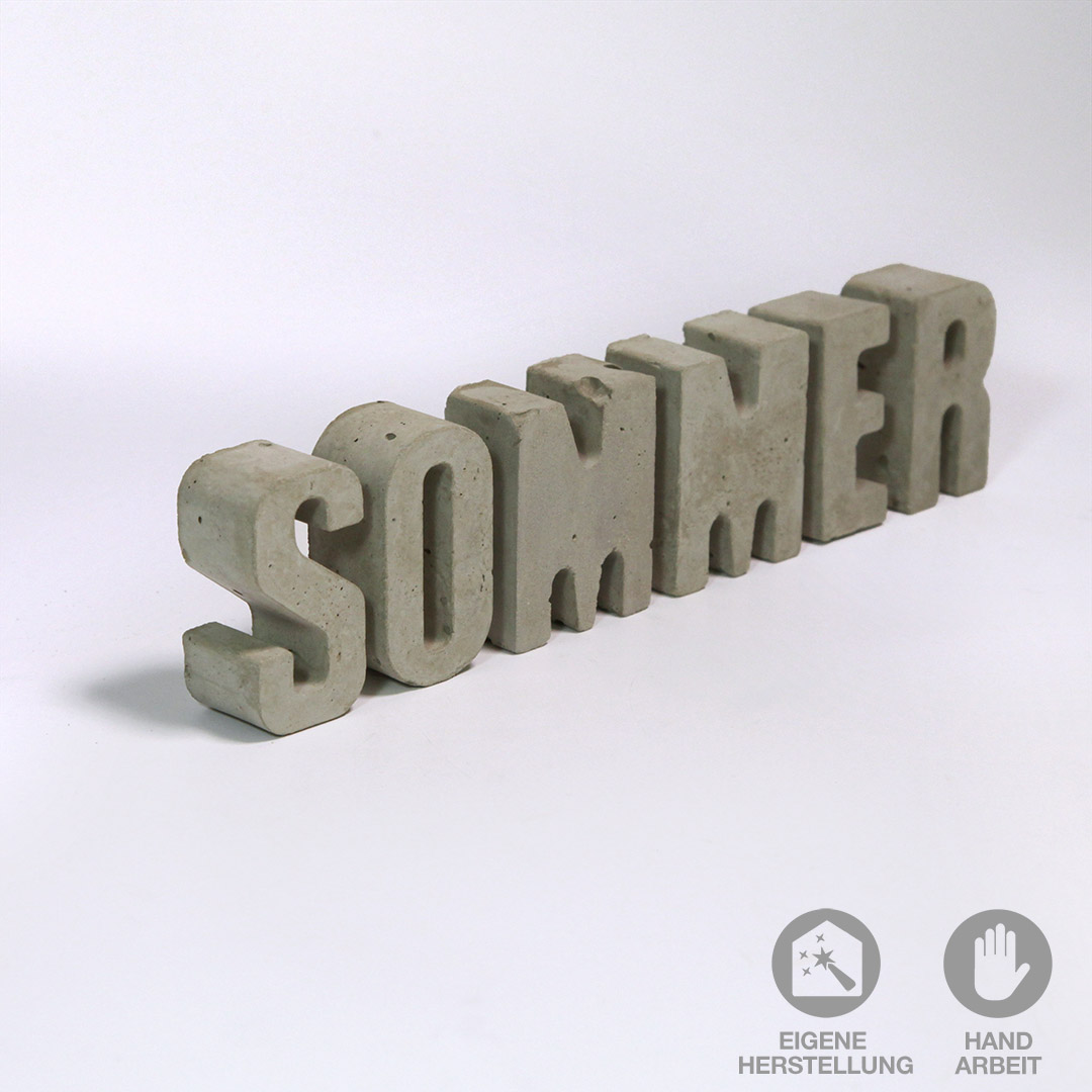 Das Wort "SOMMER" aus handgefertigten Beton-Buchstaben als Dekoration