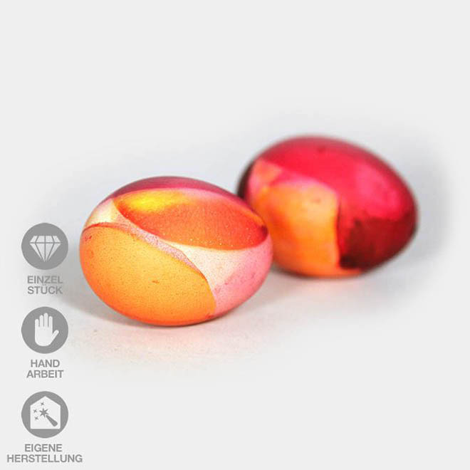 Zwei orange-rot-gelb gefärbte Eier mit Wende-Technik