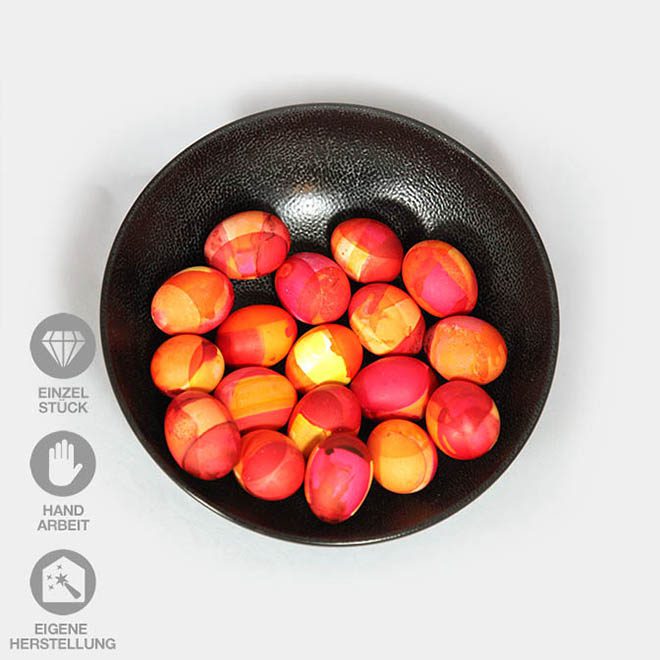 Eine Schale voller handgefärbter Eier in verschiedenen Rot-Tönen