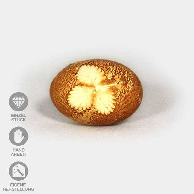 Hühnerei gefärbt mit alter Zwiebeltechnik und einem Erdbeer-Blatt