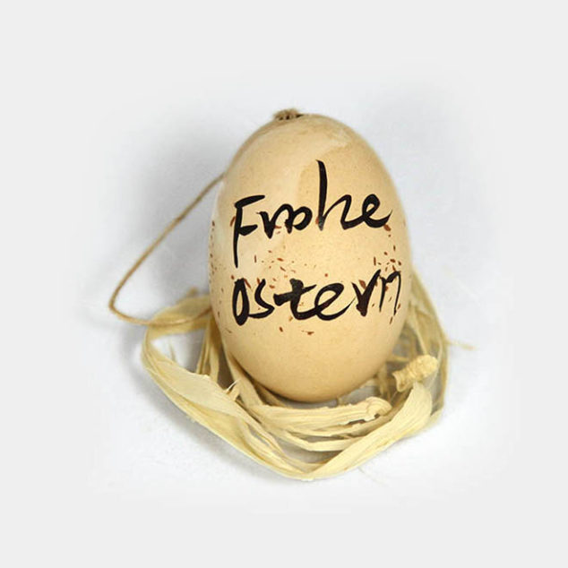 Beiges Hühner-Ei bemalt mit "Frohe Ostern"