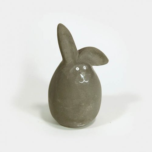 Ein grauer Zement-Hase in Form eines Eis mit Knick-Ohr
