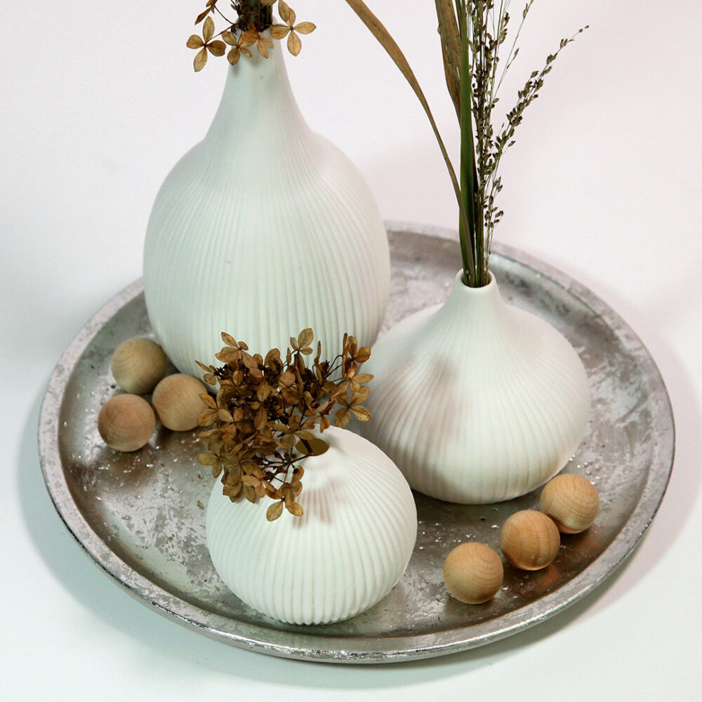 Ausschnitt des Scandi-Style-Tabletts mit drei weißen, gerillten Vasen,