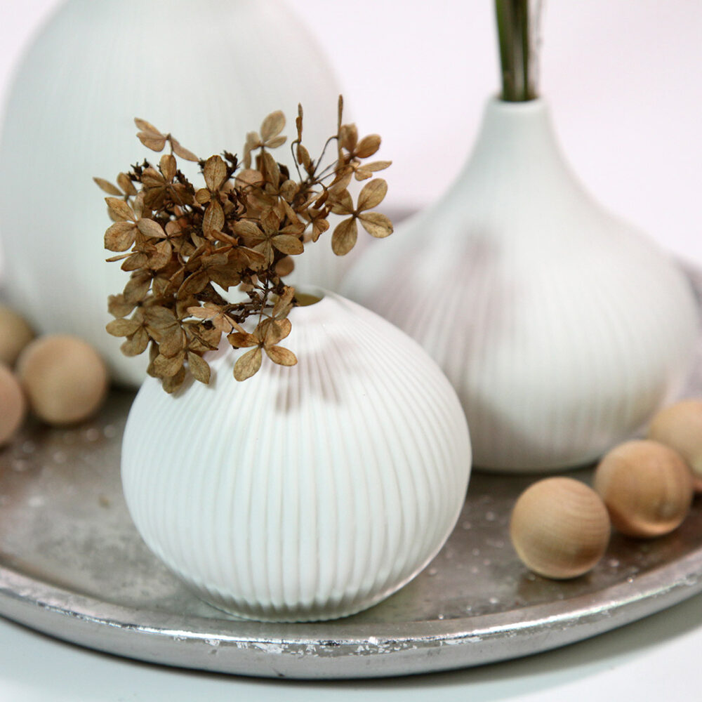 Scandi-Style Deko-Teller in silber mit drei weißen, gerillten Vasen und Trocken-Blumen.