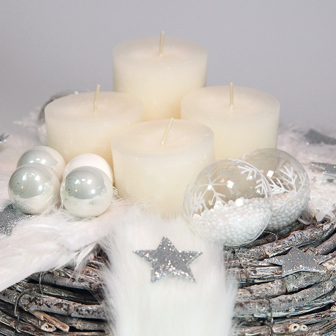 Pompöser, weißer Adventskranz aus Holz mit weißen Glas-Kugeln und Glas-Kugeln mit Kunst-Schnee befüllt und mit Schneekristallen bemalt, weißen Kerzen,, weißen Schneekristallen und weißem Fell-Band, dekoriert mit silbernen Sternen.