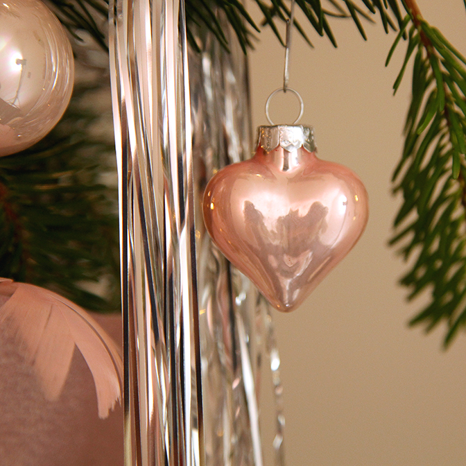 Ein Ausschnitt (Glas-Anhänger Herz) unseres Weihnachtsbaumschmuck Komplett-Sets "rosa", welches für einen kleinen, wie mittleren Weihnachtsbaum angeboten wird. Dieses besteht unter anderem aus Weihnachtsbaum-Kugeln aus Glas in einem zarten hellrose-creme Mix. Weiter ist er üppig und pompös mit glitzernden Kunst-Schleifen, Sternen, Glaskugeln in Form von Zapfen, Blumen und Sternen sowie einer Limetta-Girlande bestückt.