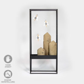 Dekorativer, schwarzer Metall-Rahmen befüllt mit Holz-Häuserzeile und Wäscheklammer-Engeln.