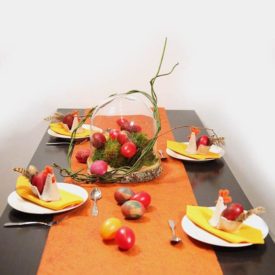 Wunderschöne, orange-rote Ostertafel mit Hennen und Eiern