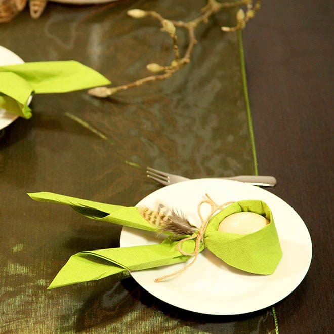 grüne Serviette und Ei zum Osterhasen gebunden