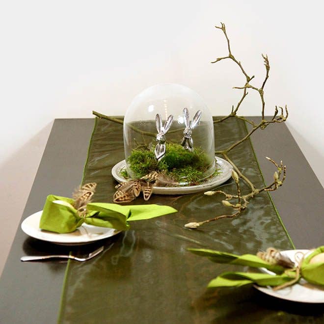 grün-silberne Ostertafel mit Glasglocke, Moos und zwei silbernen Hasen
