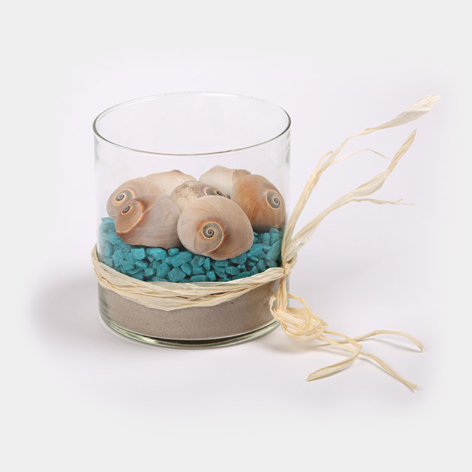 Unsere Deko-Vase Sommer "Ozean" besteht aus einer Glas-Vase befüllt mit feinstem Quarzsand, türkis gefärbten Deko-Steinen und Schnecken-förmigen Muscheln.